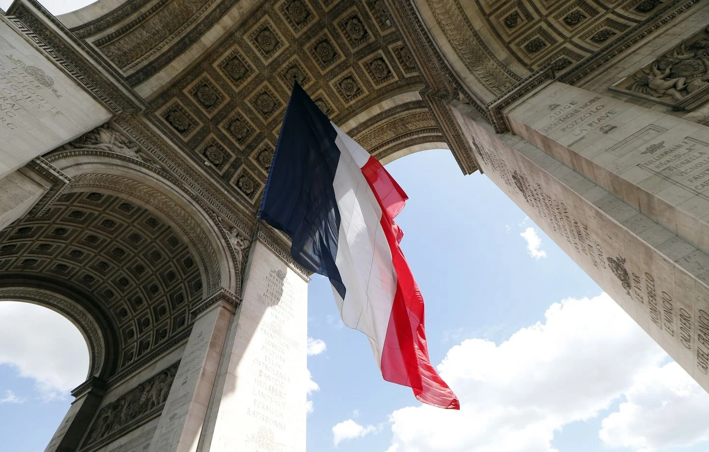 Le drapeau français flotte sous la voûte de l'Arc de triomphe, à Paris.