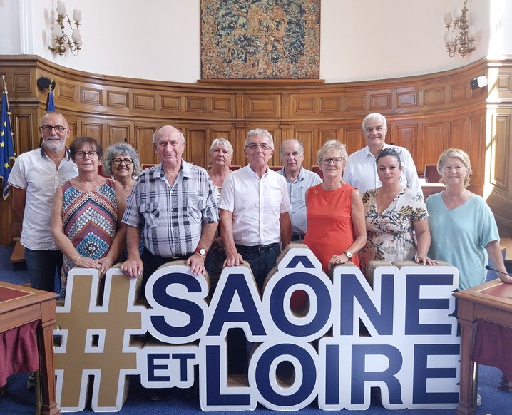 Les élus du groupe Gauche 71 posent dans la salle de l'Assemblée départementale, derrière des lettres géantes Saône-et-Loire